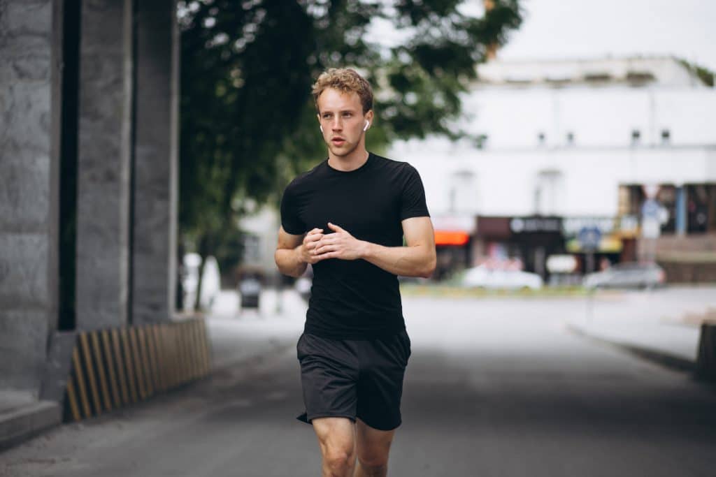 Hombre joven corriendo al aire libre en la ciudad durante la ma帽ana - promoviendo el ejercicio y la salud cardiovascular para la Semana de la Salud Masculina y la fertilidad masculina.