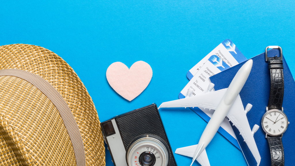 Diseño plano de elementos esenciales para las vacaciones: sombrero, cámara, reloj, maqueta de avión, billetes y un corazón que simboliza los viajes con conciencia de fertilidad.