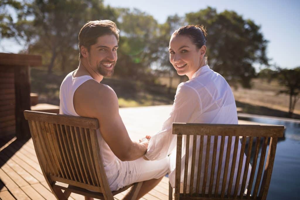 Romantic couple sitting together on chair at safari vacation