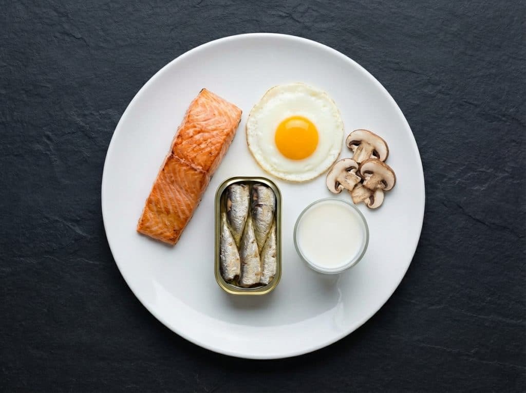Imagen que muestra alimentos ricos en vitamina D, como el salmón, los huevos, las setas y la leche, con etiquetas nutricionales para la fertilidad masculina.